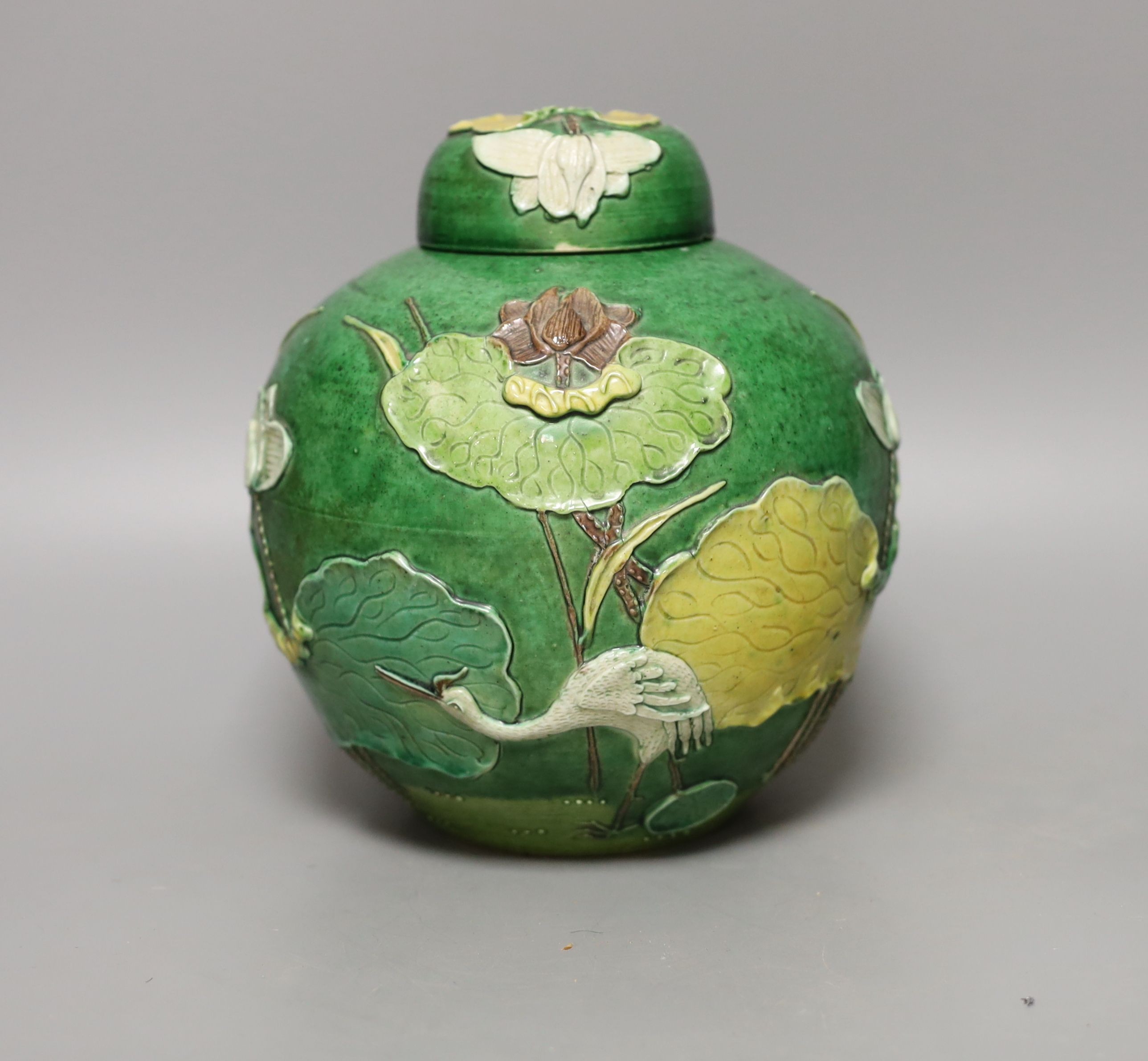 An early 20th century Chinese green-glazed ‘lotus’ jar and cover 18cm